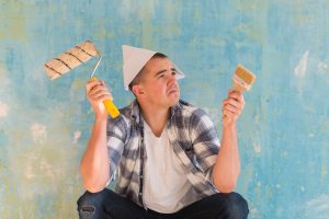 house painting cost Chicago: man holding paint brushes