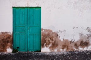 exterior painting Chicago - Weathered turquoise door on wall